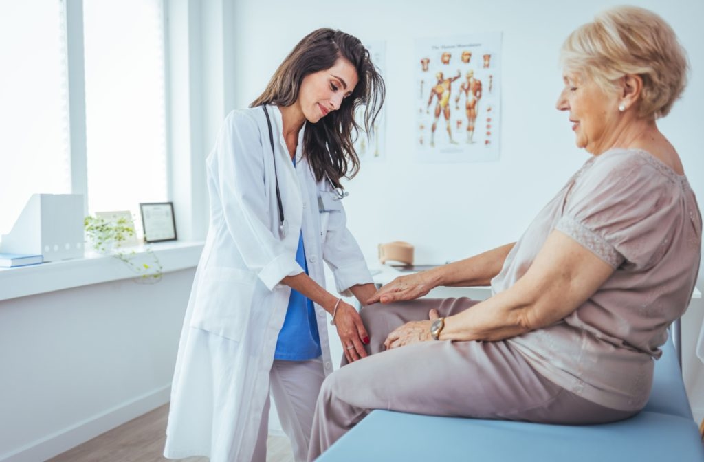 A doctor checks out a senior's knee after a fall.