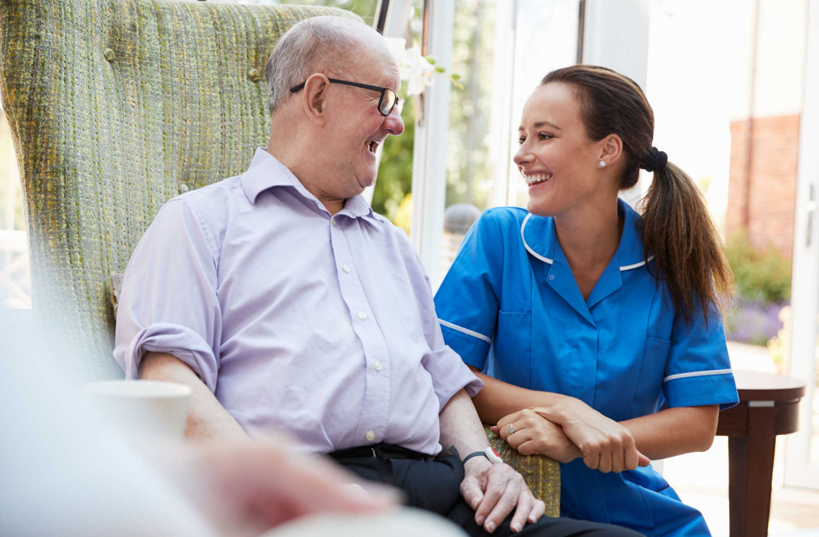 A female nurse talking to a male memory care patient.