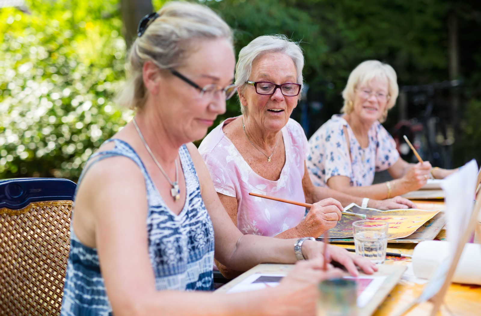 A group of senior women spending their afternoon painting outdoors.